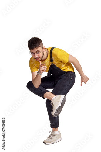 Full-length portrait of a funny guy dancing in studio isolated on white background.