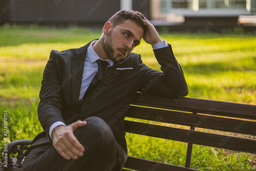 Worried businessman sitting outdoor.Toned image. Worried businessman sitting outdoor.Toned image.