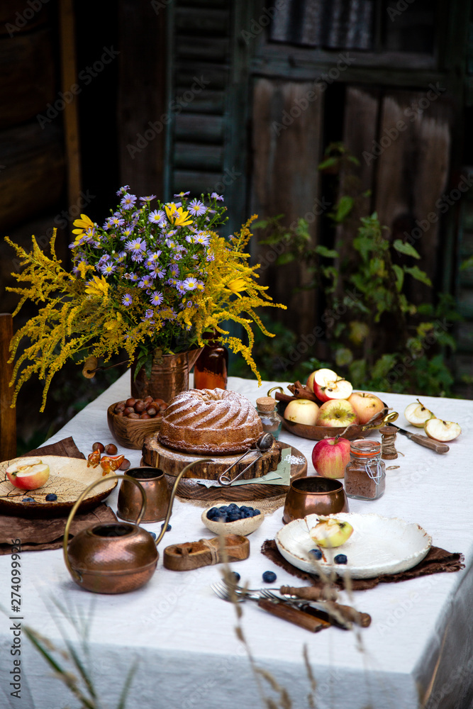beautiful outdoor still life in country garden with bundt cake on wooden stand on rustic table