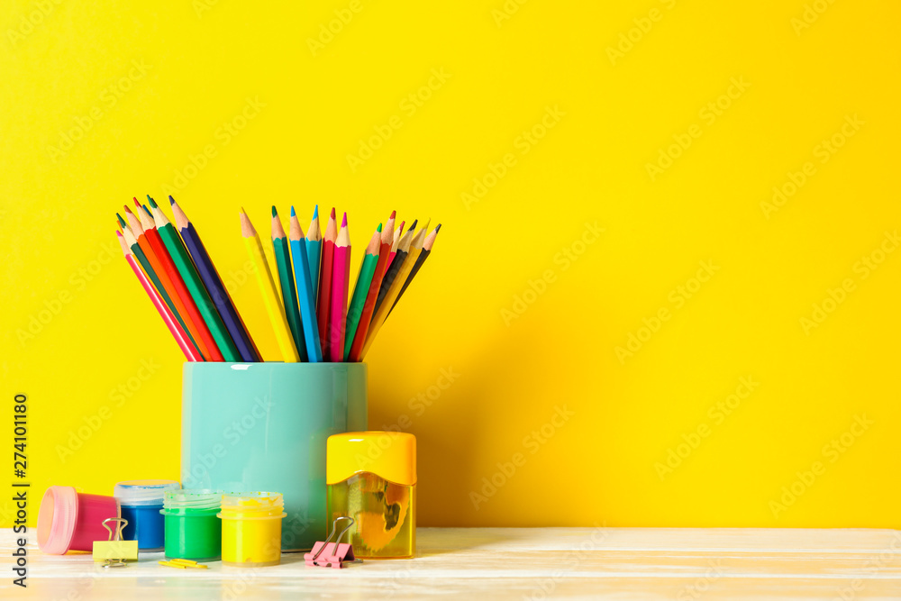 Obraz premium School supplies on wooden table against color background, space for text