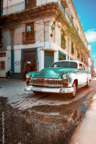 Antique car with reflections on a water puddle in Old Havana © kmiragaya