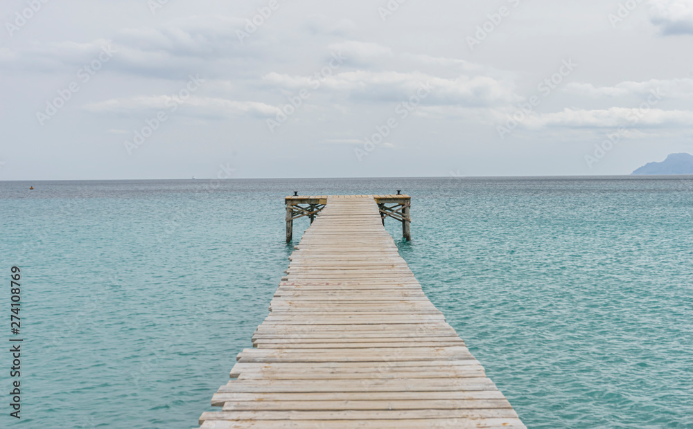 Wooden pier, calm turquoise waters in the Mediterranean Sea, holiday scenes with a sense of calm