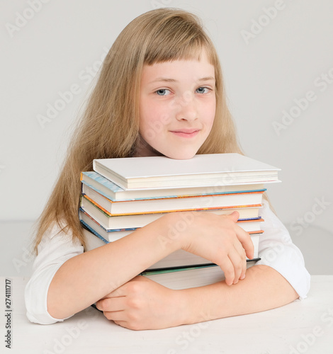 Cute girl with a stack of books;