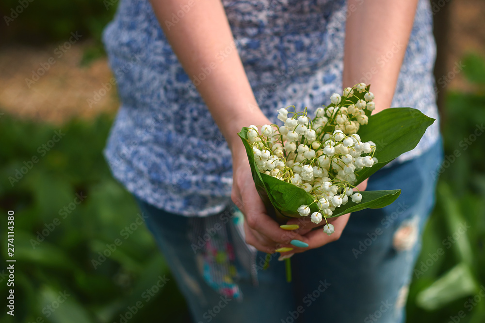 Young girl holding spring lilies of the valley