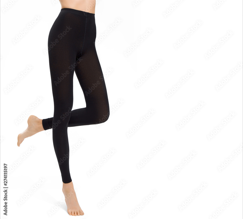 Legs of sexy young caucasian woman in black leggings on white background