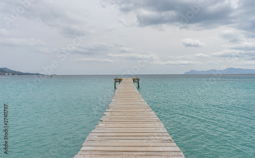 Fototapeta Naklejka Na Ścianę i Meble -  Wooden pier, calm turquoise waters in the Mediterranean Sea, holiday scenes with a sense of calm