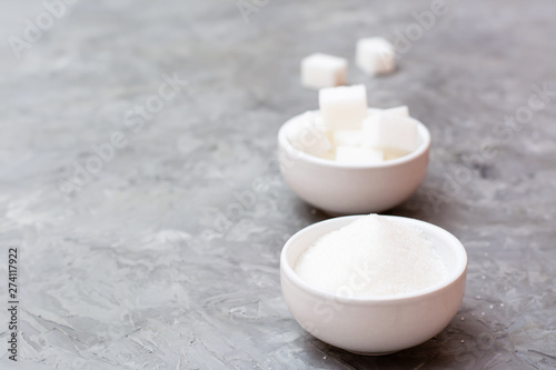 Concept advantages of granulated sugar over refined sugar. Two types of sugar in white bowls on the table, standing next to each other