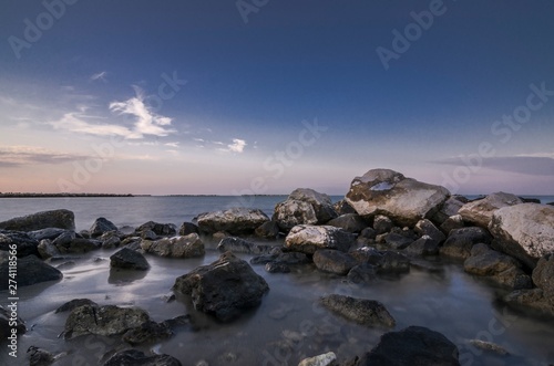 Beautiful coastal seascape with rocks in the foreground at sunset