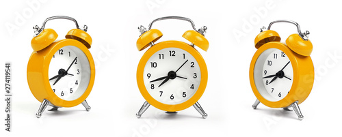 Three yellow alarm clock over white photo