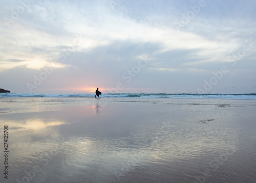 surfista sozinho na praia ao por do sol