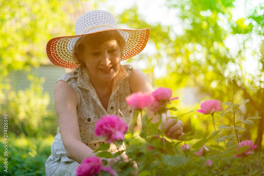 adult female florist working with flowers in the garden with flowers