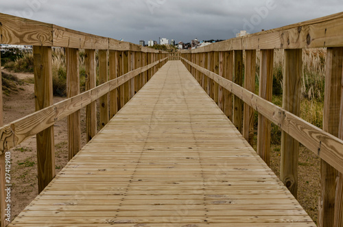 Valokuvatapetti wooden footbridge over the beach in cloudy winter day