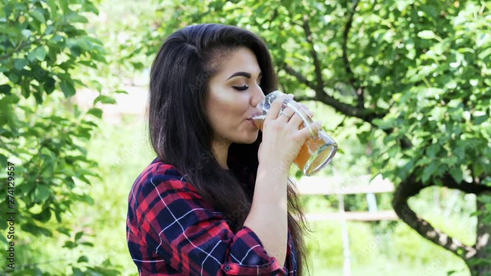 Side portrait of young happy woman drinks beer from glass, quenches thirst. Side portrait of young happy woman drinks beer from glass, quenches thirst.