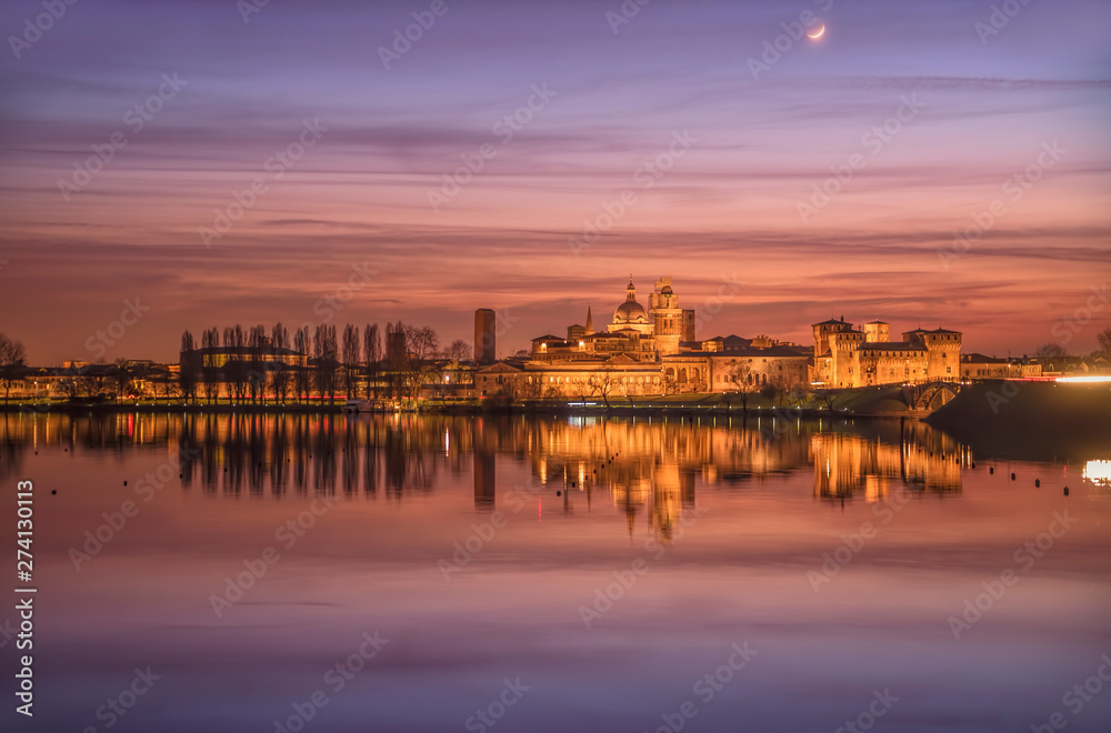 UNESCO World Heritage site Mantua city illuminated after the sunset with reflections on the lake