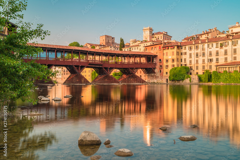 Naklejka premium Bassano del Grappa before the sunset and city reflections in the Brenta River
