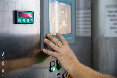 Fotografia Worker clicks on touch screen of control panel on industrial equipment of bevera