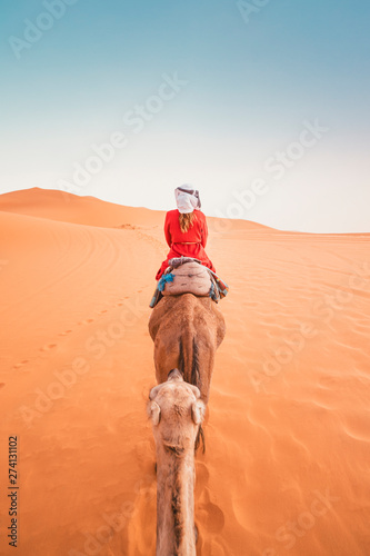 A tourist woman on the dromedary in Morocco desert