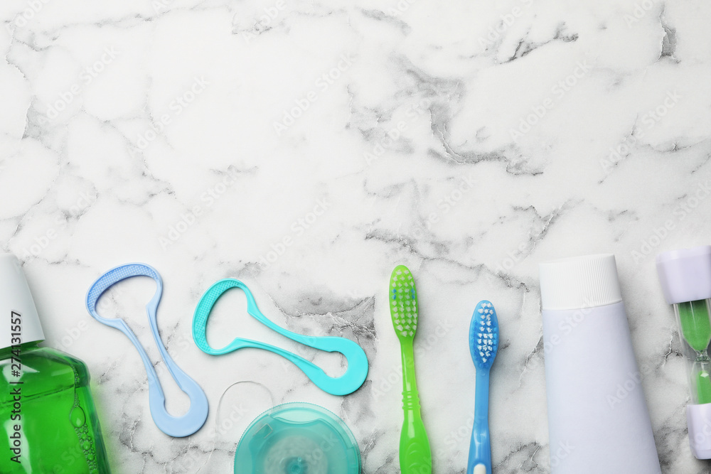 Flat lay composition with tongue cleaners and teeth care products on marble background. Space for text Flat lay composition with tongue cleaners and teeth care products on marble background. Space for text