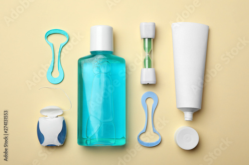 Flat lay composition with tongue cleaners and teeth care products on color background