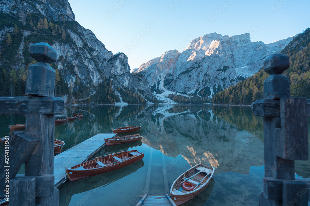 Pragser Wildsee at sunrise with boats and reflections on water