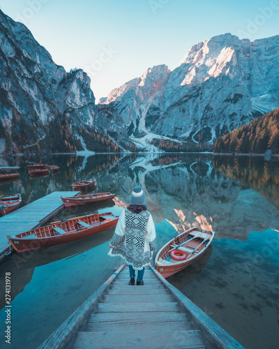 Pragser Wildsee at sunrise with a girl on the pier