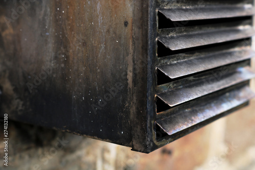 Old oil boiler exhaust flue. Showing the accumulation of soot around the vent cover which if left to block up could cause carbon monoxide build up in the home. Soot shows inefficient burning. photo