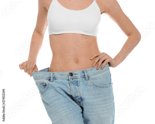 Slim young woman with smooth gentle skin in oversized jeans on white background, closeup. Beauty and body care concept