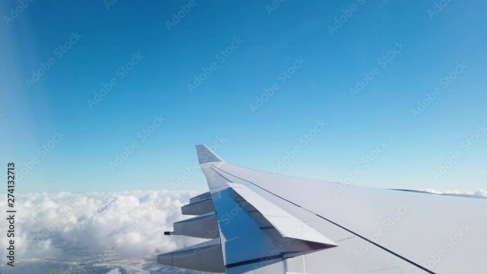 Wing of an airplane flying above the clouds Wing of an airplane flying above the clouds