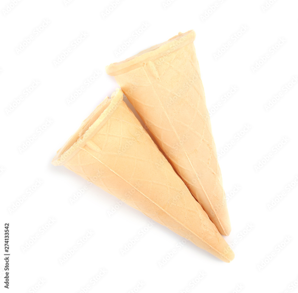 Naklejka premium Empty crispy waffle cones for ice cream on white background, top view