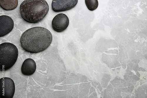 Spa stones on grey background, top view. Space for text