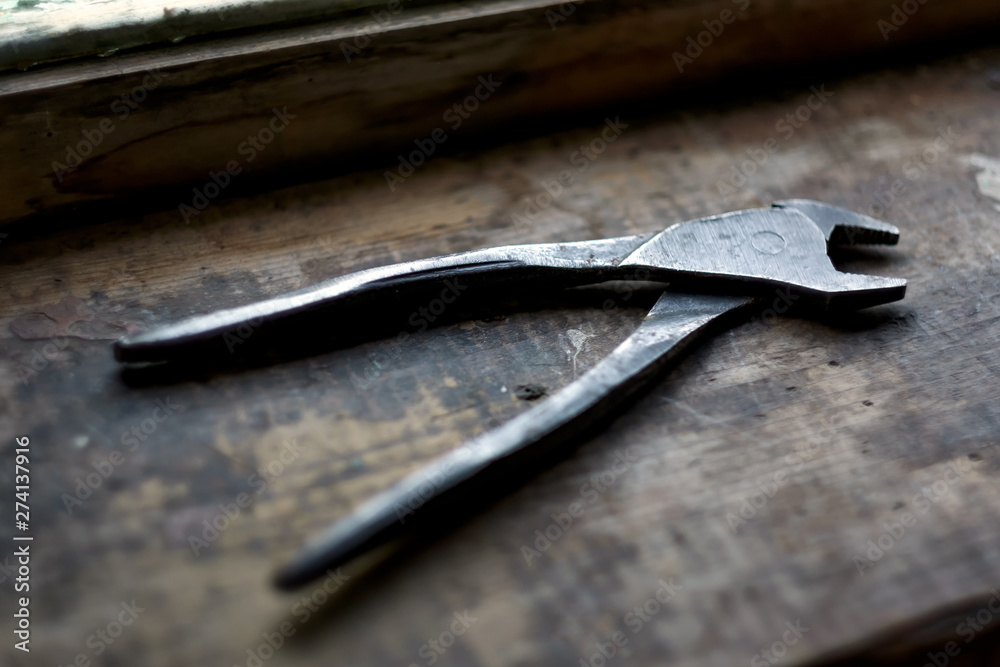 Old rusty plier on wooden shelf near window. Tool for carpentry work. Old rusty plier on wooden shelf near window. Tool for carpentry work.