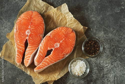 Two fresh raw salmon steaks on a gray concrete background. Healthy food. Top view. Copy space. 