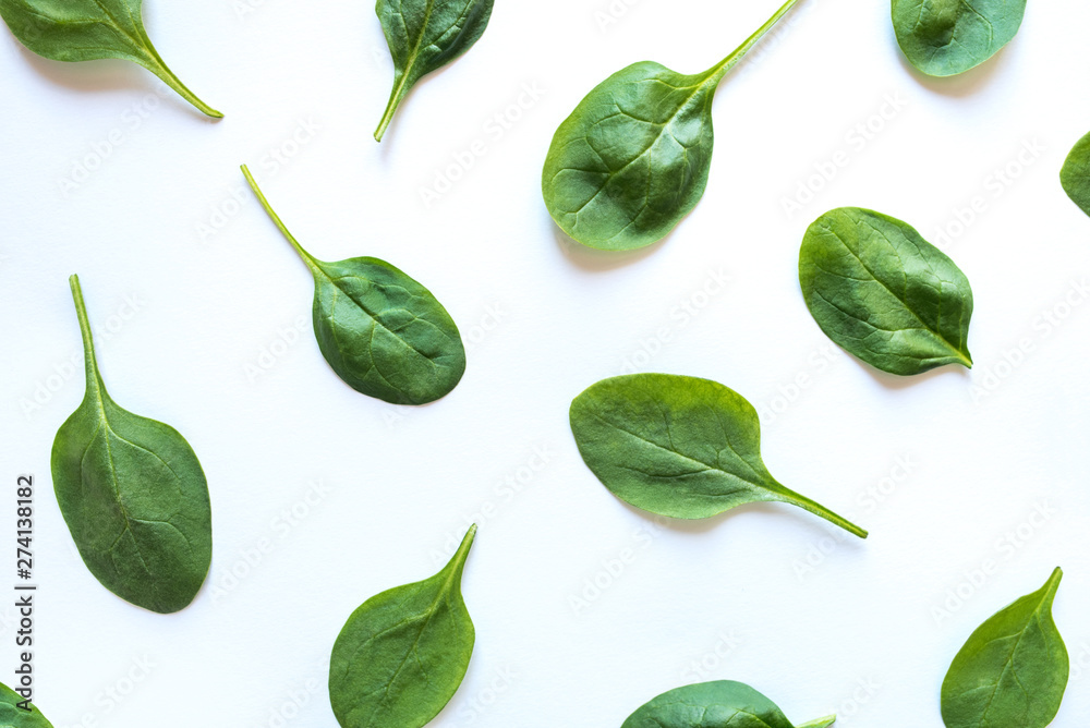 Beautiful pattern of fresh spinach leaves on white background. Flat lay. Beautiful pattern of fresh spinach leaves on white background. Flat lay.