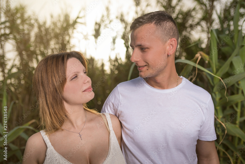 Fototapeta premium Loving man and happy woman in a spring blooming park. Happy mature couple in love embracing outdoor, looking each other
