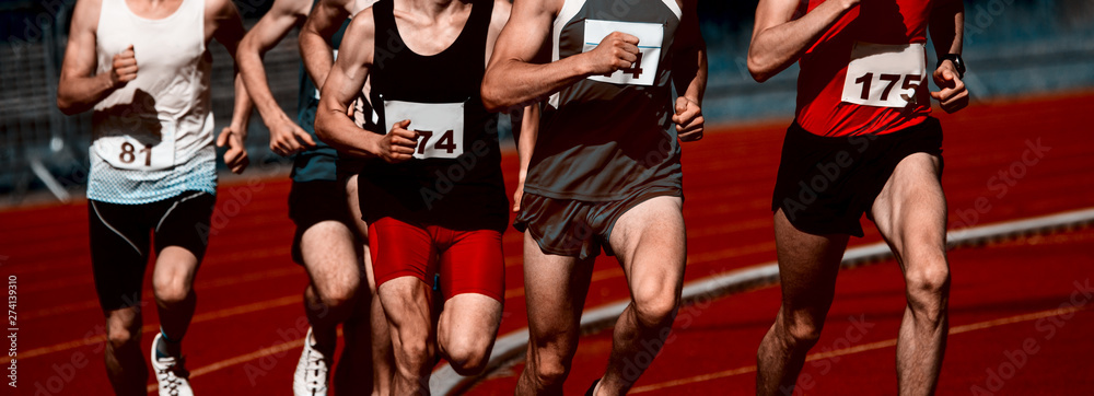 Athletics people running on the track field. Sunny day Athletics people running on the track field. Sunny day