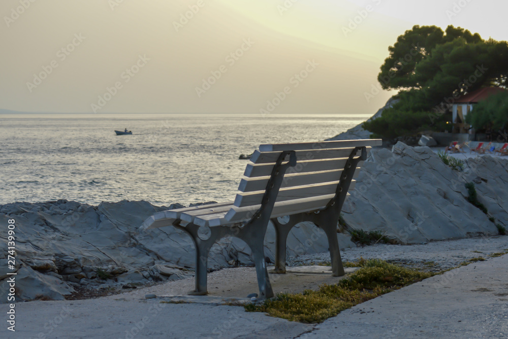 Bench at sunset background on Adriatic sea in Brela, Croatia