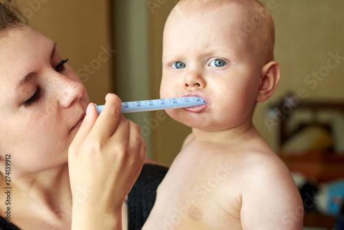 Mom gives her child medicine through a syringe