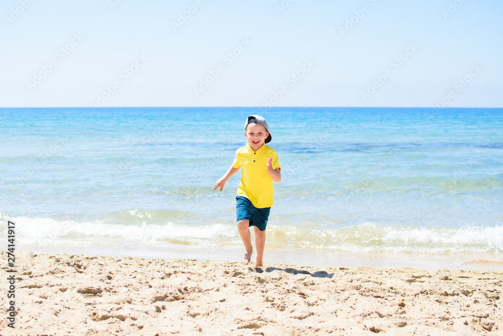 The little boy running near the sea.