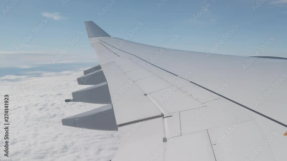Wing of an airplane flying above the clouds Wing of an airplane flying above the clouds