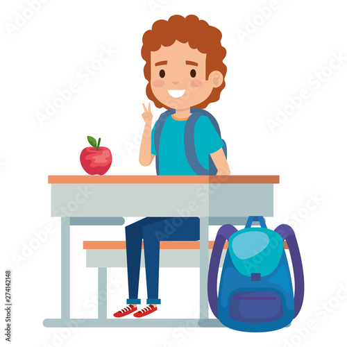 student boy seated in school desk with apple and bag