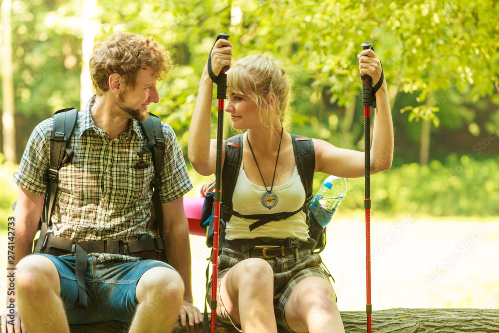 Naklejka premium Hiking couple backpackers resting on forest trail