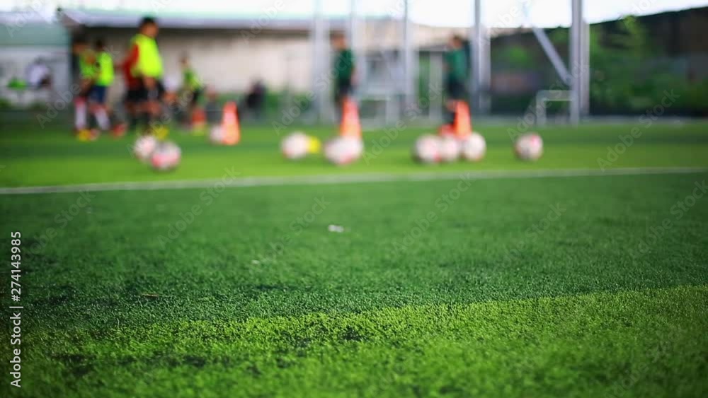 green artificial turf with blurry soccer players are training background. green artificial turf with blurry soccer players are training background.