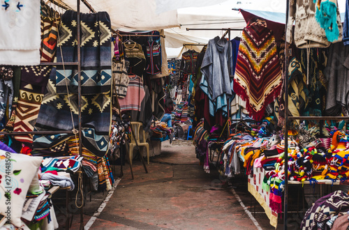 Crowded stalls with indigenous woven fabric and souvenirs in Otavalo, Ecuador, one of the biggest artisanal markets in South America © Lozzy