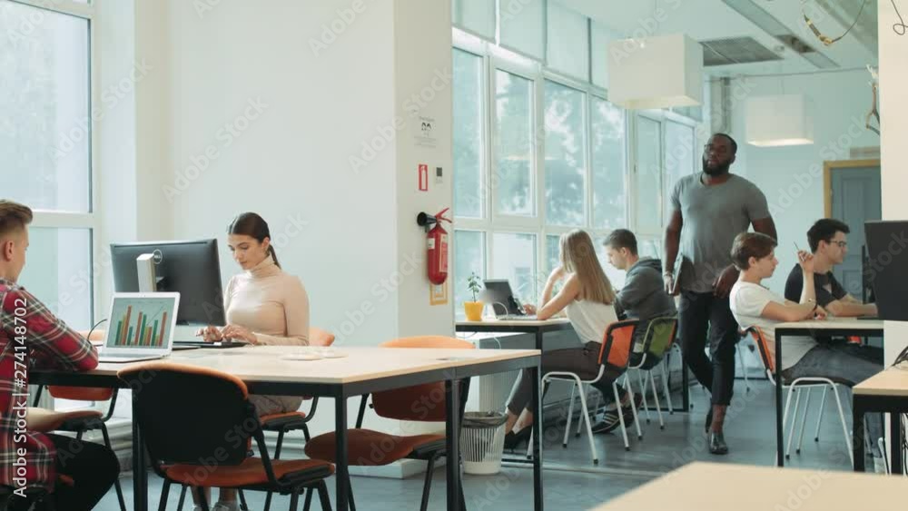 Serious man coming in coworking space. Black man planning to work in open space.