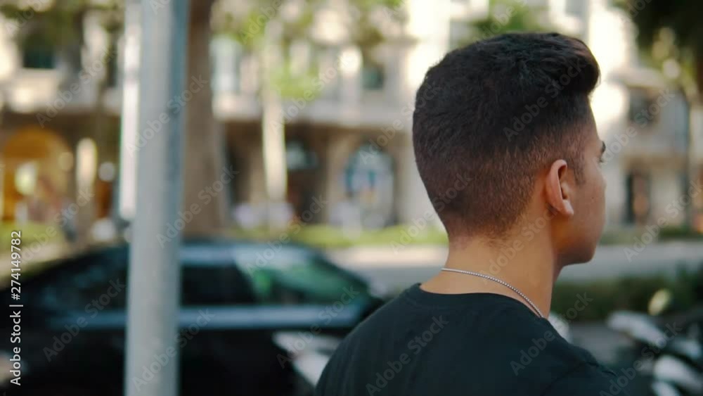 Young fashionable handsome man on the street of modern city. He is walking