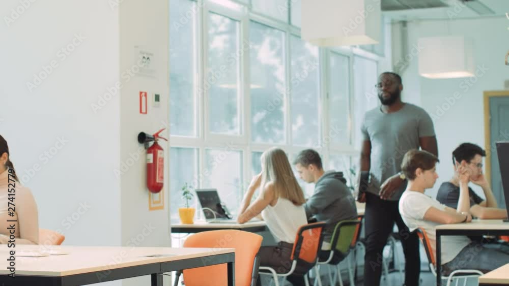 African man coming in coworking space. Closeup serious man opening laptop. African man coming in coworking space. Closeup serious man opening laptop.