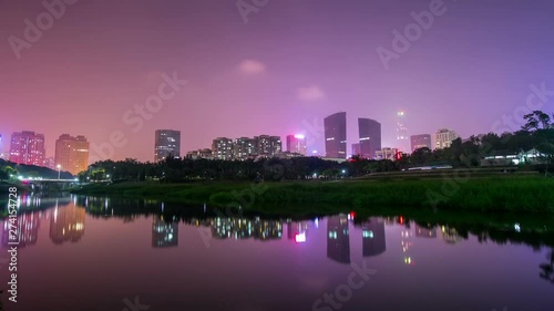 Shenzhen China Colorful Night Cityscape Timelapse With Towers and Buildings and Their Reflection on Park Lake Water photo