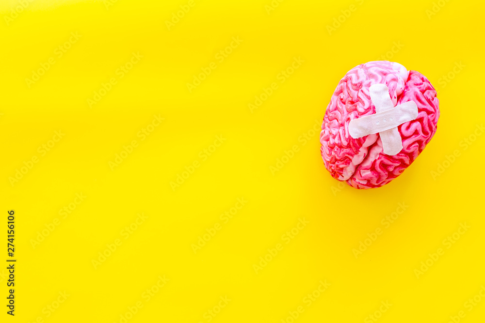 Mental health concept with patches on brain on yellow background top view mockup Mental health concept with patches on brain on yellow background top view mockup