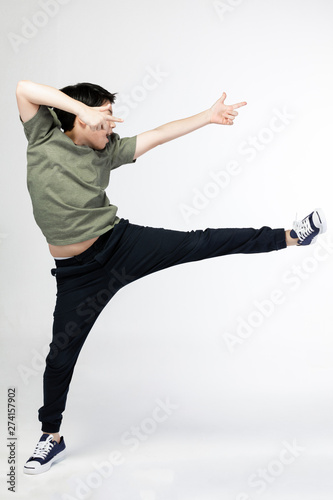 Portrait of happy little Asian child jumping isolated on gray