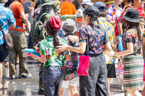 crowded Thai people  in colorful shirts and tourists joy Songkran Festival on the road